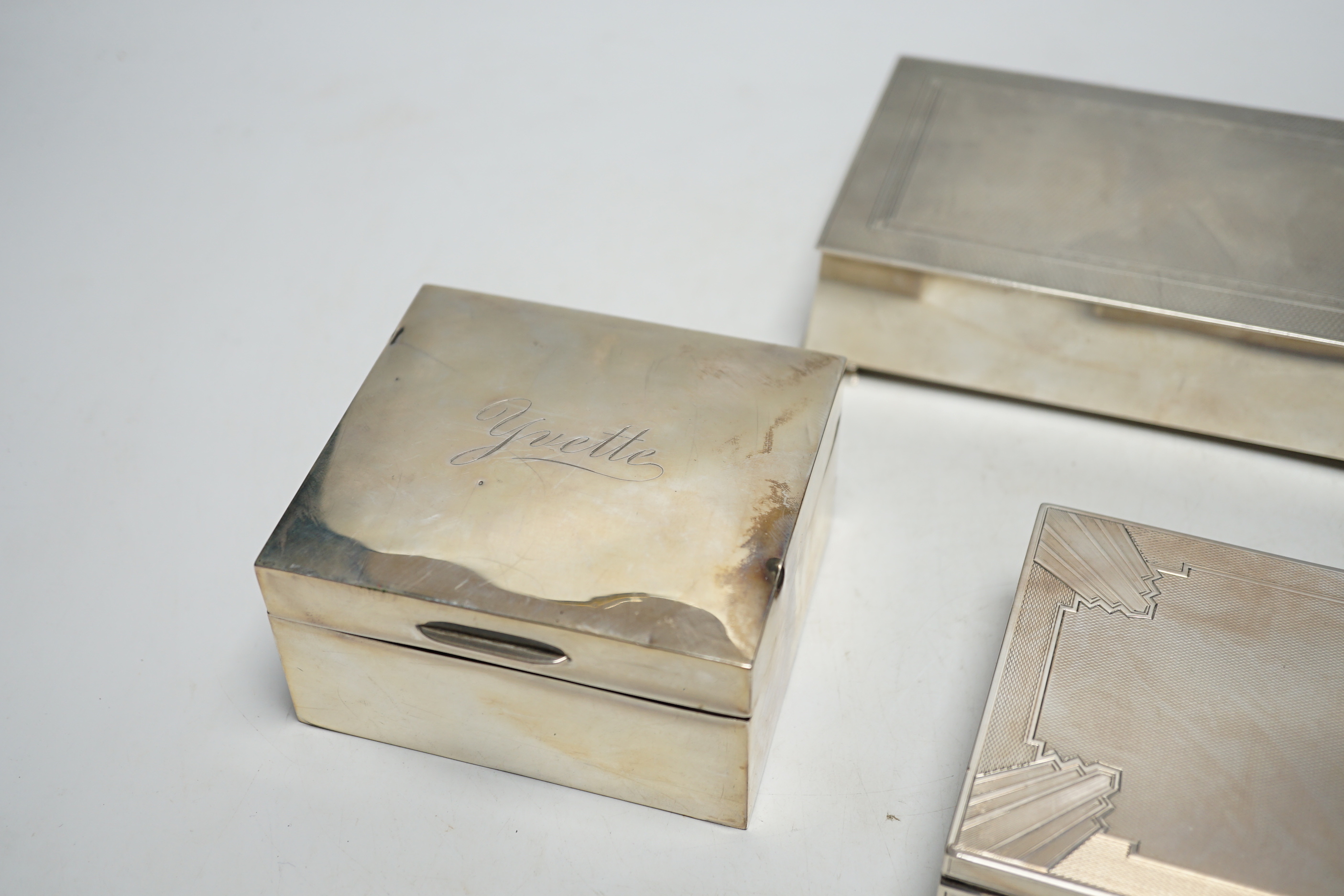 Three assorted silver mounted cigarette boxes including two 1930's, one by Goldsmiths & Silversmiths Co Ltd, largest 15.6cm.